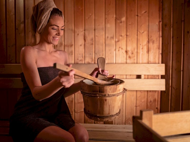 Žena v sauně držící ochlazovací vědro