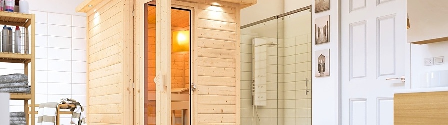 Domácí finská sauna vedle police s ručníky